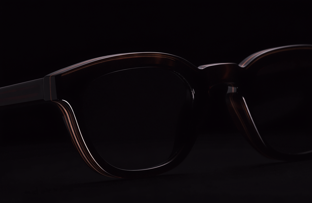 Thick handcrafted dark acetate sunglasses under a single hard light on a black background, Jacques Marie Mage alternatives guide