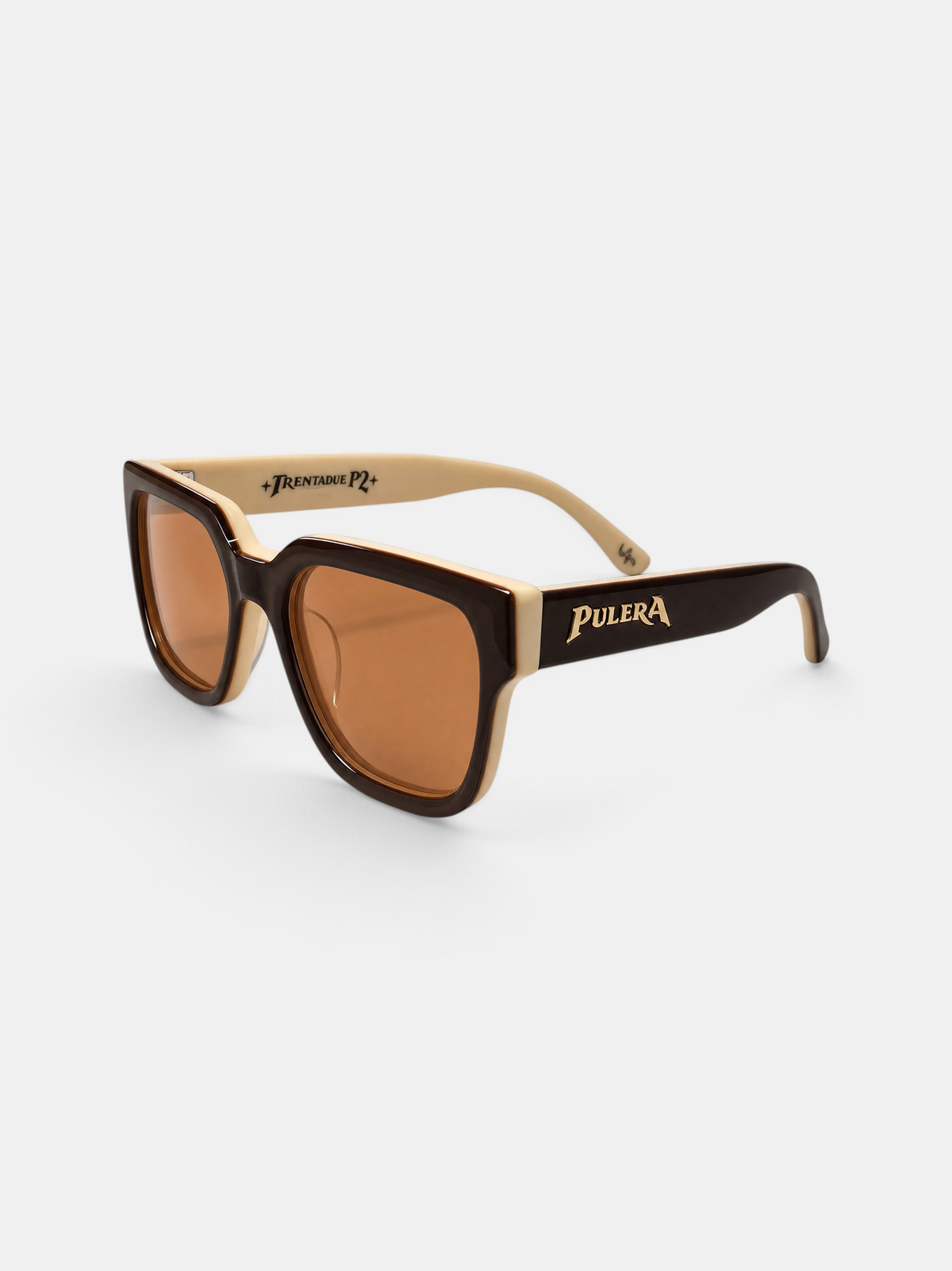 Pulera sunglasses with dark brown and beige acetate frames, brown lenses, and gold lettering on the temples, shown on a light gray background.